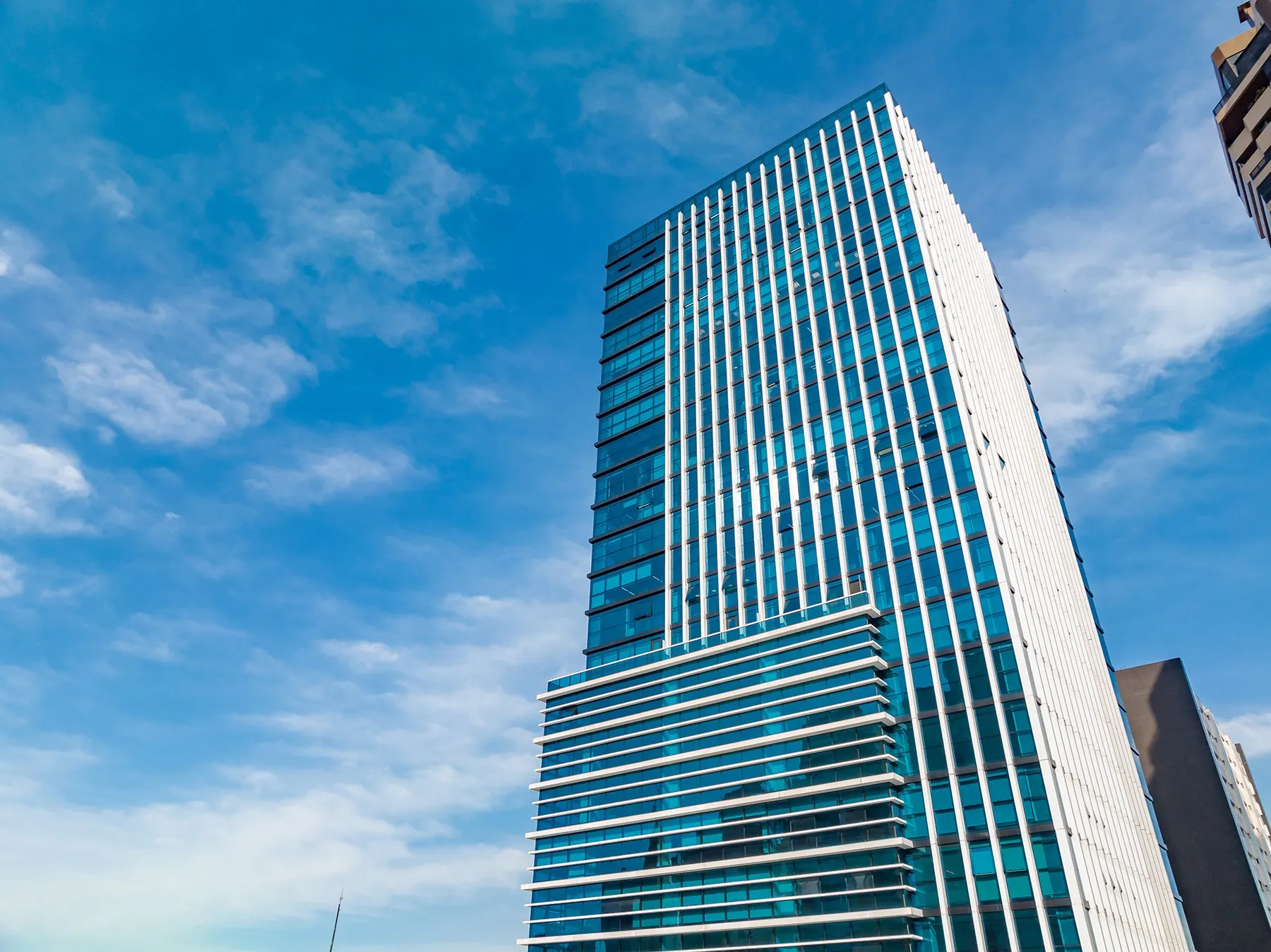 Torre envidraçada vista de baixo contra o céu